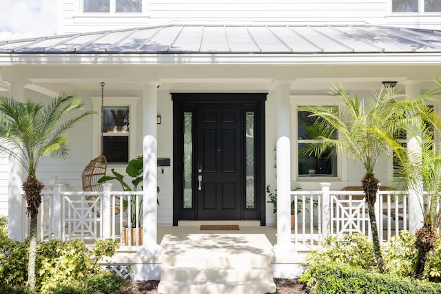 3245 Wymberly Dr, Jupiter, FL 33458 - property entrance featuring a standing seam roof, a porch, and a metal roof