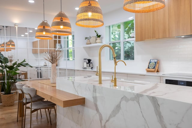 3245 Wymberly Dr, Jupiter, FL 33458 - kitchen featuring modern cabinets, healthy amount of natural light, decorative backsplash, recessed lighting, and wood finished floors