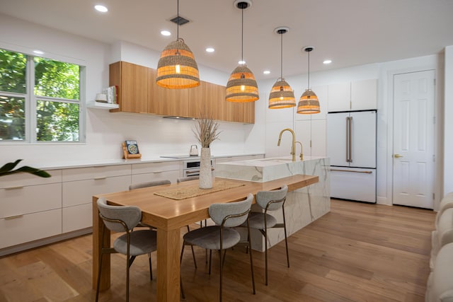 3245 Wymberly Dr, Jupiter, FL 33458 - kitchen with high end white refrigerator, modern cabinets, light wood-style floors, recessed lighting, and hanging light fixtures