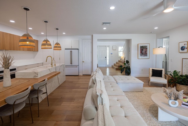 3245 Wymberly Dr, Jupiter, FL 33458 - living area with light wood-type flooring, recessed lighting, stairway, and a ceiling fan