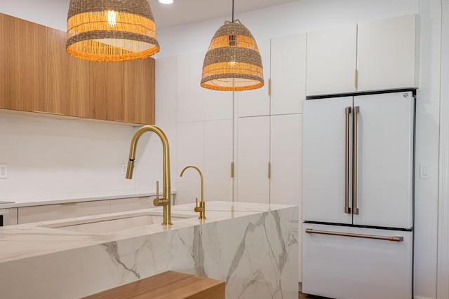 3245 Wymberly Dr, Jupiter, FL 33458 - kitchen featuring high end white refrigerator, modern cabinets, white cabinetry, light stone countertops, and pendant lighting