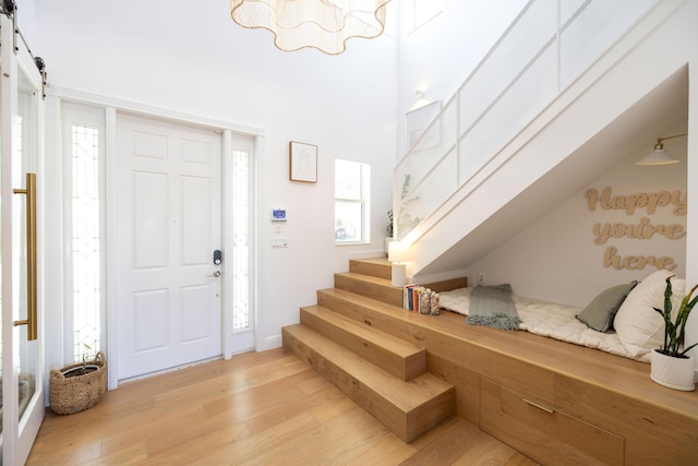 3245 Wymberly Dr, Jupiter, FL 33458 - foyer featuring light wood finished floors, stairway, and a barn door