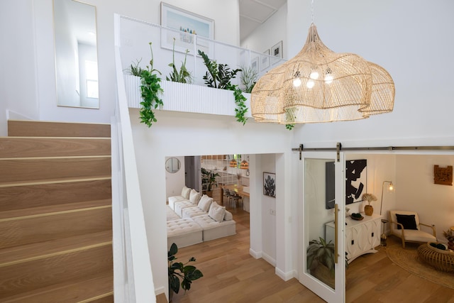 3245 Wymberly Dr, Jupiter, FL 33458 - staircase with a barn door, wood finished floors, and a chandelier