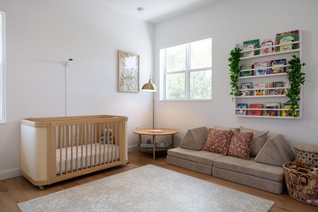 3245 Wymberly Dr, Jupiter, FL 33458 - bedroom featuring wood finished floors and a nursery area