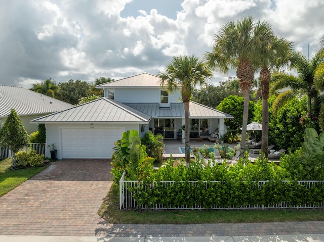 3245 Wymberly Dr, Jupiter, FL 33458 - view of front of home featuring a standing seam roof, a metal roof, a garage, decorative driveway, and a porch