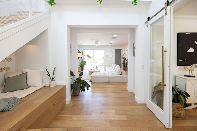 3245 Wymberly Dr, Jupiter, FL 33458 - corridor featuring a barn door, light wood-style floors, and recessed lighting