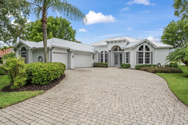 918 SW Blue Stem Way, Stuart, FL 34997 - view of front of property with french doors, an attached garage, decorative driveway, and stucco siding