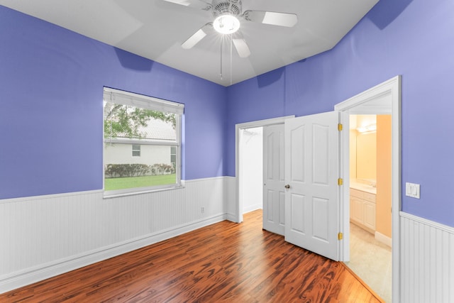 918 SW Blue Stem Way, Stuart, FL 34997 - unfurnished bedroom with a wainscoted wall, wood finished floors, and a ceiling fan