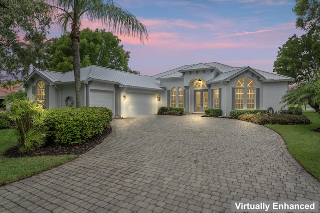 918 SW Blue Stem Way, Stuart, FL 34997 - ranch-style home featuring french doors, stucco siding, decorative driveway, a garage, and a standing seam roof