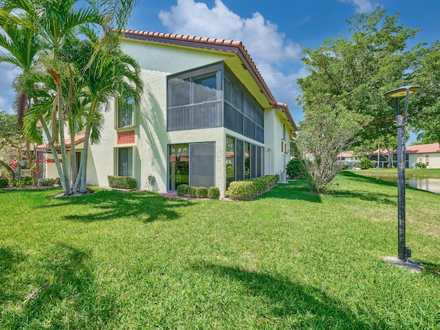 10828 Lake Palm Ln Unit 202, Boynton Beach, FL 33437 - back of property featuring stucco siding, a yard, a tiled roof, and a sunroom