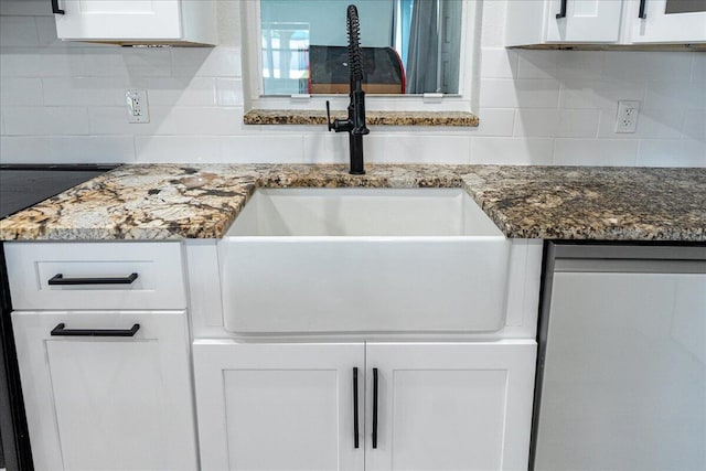 673 NE Horizon Ln, Port Saint Lucie, FL 34983 - kitchen view of decorative backsplash, white cabinetry, and dark stone counters