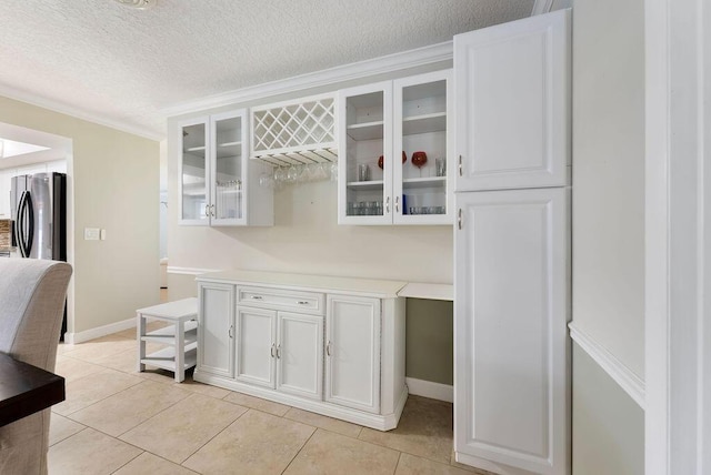 1546 35th Ave, Vero Beach, FL 32960 - kitchen featuring glass insert cabinets, a textured ceiling, freestanding refrigerator, white cabinetry, and light countertops
