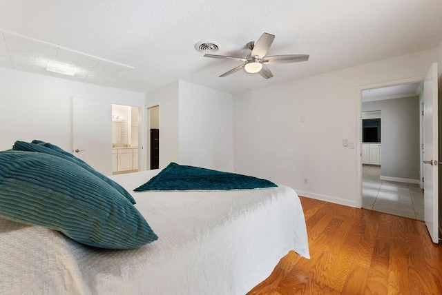 1546 35th Ave, Vero Beach, FL 32960 - bedroom with light wood finished floors, ceiling fan, and ensuite bathroom