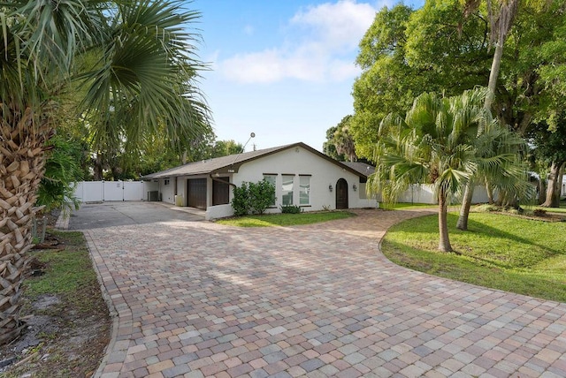 1546 35th Ave, Vero Beach, FL 32960 - single story home with decorative driveway, stucco siding, a garage, and a gate