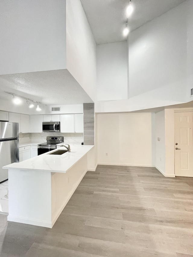 7832 Sonoma Springs Cir Unit 203, Lake Worth, FL 33463 - kitchen featuring track lighting, appliances with stainless steel finishes, light countertops, a peninsula, and white cabinets