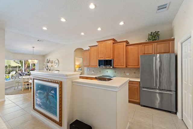 5885 SE Forest Glade Trl, Hobe Sound, FL 33455 - kitchen featuring stainless steel appliances, a kitchen island with sink, light countertops, light tile patterned floors, and decorative backsplash
