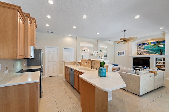 5885 SE Forest Glade Trl, Hobe Sound, FL 33455 - kitchen with stainless steel appliances, a ceiling fan, light tile patterned floors, arched walkways, and light countertops