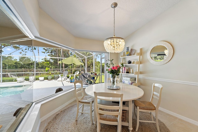 5885 SE Forest Glade Trl, Hobe Sound, FL 33455 - dining area with tile patterned flooring, a chandelier, a sunroom, and a textured ceiling