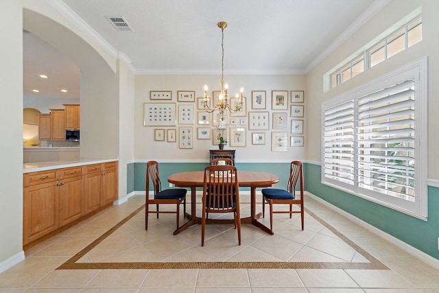 5885 SE Forest Glade Trl, Hobe Sound, FL 33455 - dining area with light tile patterned floors, inlaid floor details, a chandelier, ornamental molding, and arched walkways