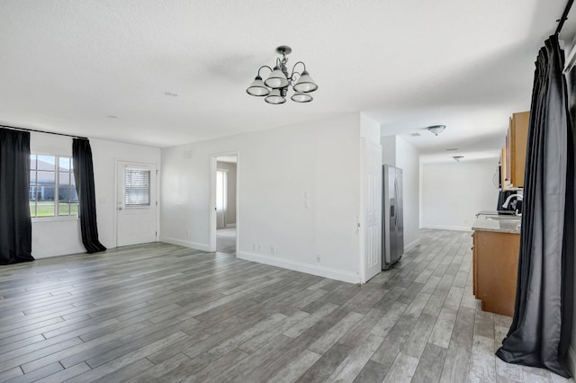 1669 SE N Blackwell Dr, Port Saint Lucie, FL 34952 - unfurnished living room with a chandelier and light wood finished floors