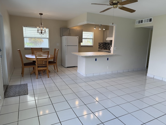 64 Waterford C, Delray Beach, FL 33446 - kitchen featuring freestanding refrigerator, tasteful backsplash, a chandelier, a ceiling fan, and a peninsula