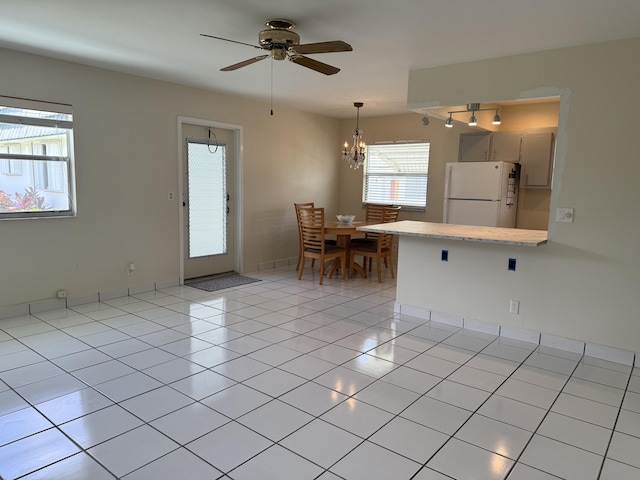 64 Waterford C, Delray Beach, FL 33446 - kitchen with freestanding refrigerator, a peninsula, light countertops, ceiling fan, and a chandelier