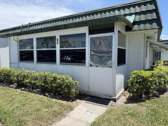 64 Waterford C, Delray Beach, FL 33446 - view of side of home with a sunroom and brick siding