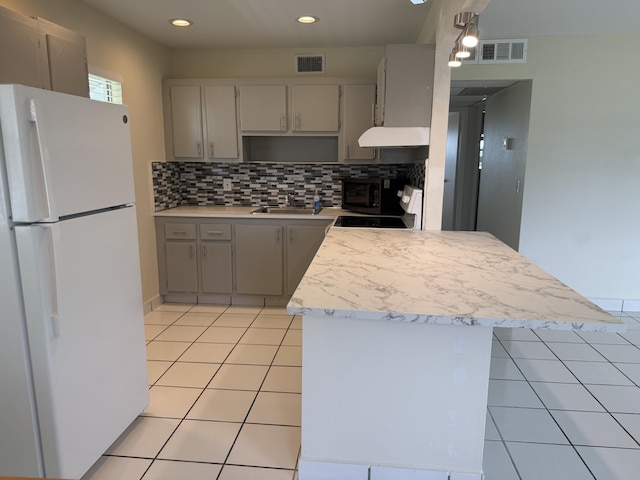 64 Waterford C, Delray Beach, FL 33446 - kitchen with freestanding refrigerator, range hood, range, light tile patterned floors, and recessed lighting