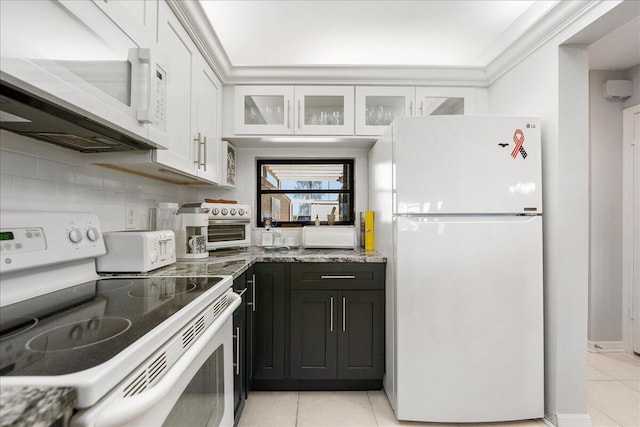 1102 SE Mitchell Ave Unit 302, Port Saint Lucie, FL 34952 - kitchen featuring white appliances, light tile patterned floors, light stone countertops, white cabinetry, and glass insert cabinets