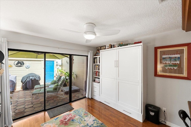1102 SE Mitchell Ave Unit 302, Port Saint Lucie, FL 34952 - bedroom with access to exterior, dark wood-style floors, ceiling fan, a closet, and a textured ceiling