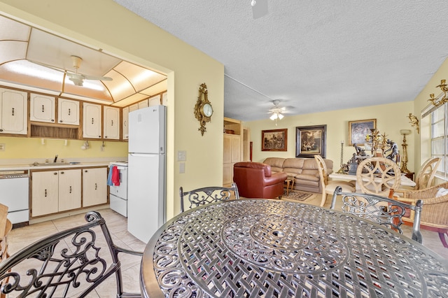 501 Normandy K, Delray Beach, FL 33484 - kitchen featuring white appliances, a ceiling fan, light countertops, a textured ceiling, and light tile patterned floors