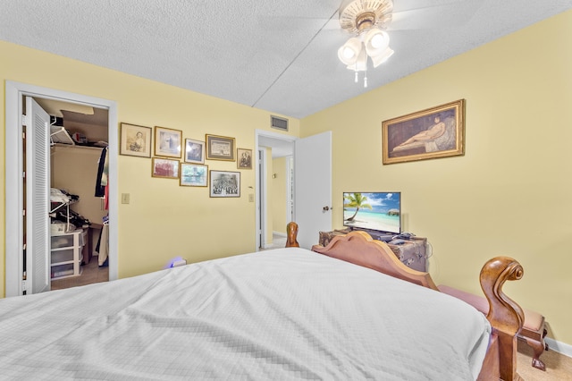 501 Normandy K, Delray Beach, FL 33484 - carpeted bedroom featuring a walk in closet, a textured ceiling, ceiling fan, and a closet