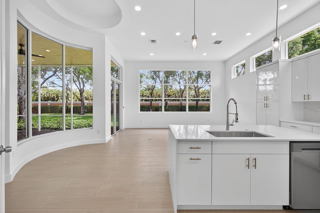 8873 Via Brilliante, Wellington, FL 33411 - kitchen featuring stainless steel dishwasher, light countertops, recessed lighting, hanging light fixtures, and white cabinets