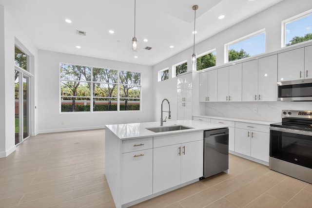 8873 Via Brilliante, Wellington, FL 33411 - kitchen with stainless steel appliances, plenty of natural light, recessed lighting, light countertops, and a center island with sink