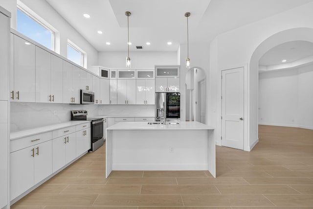 8873 Via Brilliante, Wellington, FL 33411 - kitchen featuring appliances with stainless steel finishes, arched walkways, white cabinets, and recessed lighting