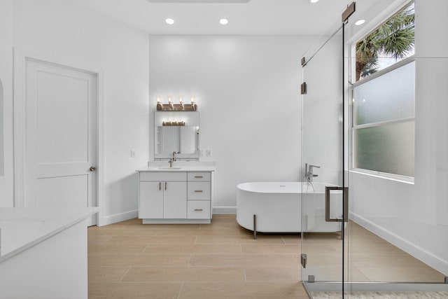8873 Via Brilliante, Wellington, FL 33411 - full bath with vanity, a freestanding tub, recessed lighting, a shower stall, and wood finish floors