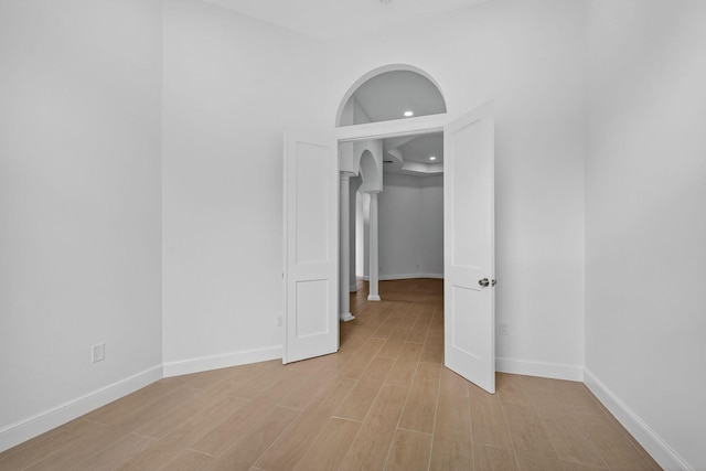 8873 Via Brilliante, Wellington, FL 33411 - unfurnished room featuring arched walkways, light wood-style floors, and recessed lighting