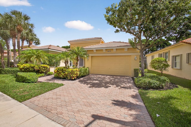 8873 Via Brilliante, Wellington, FL 33411 - mediterranean / spanish home with stucco siding, an attached garage, decorative driveway, and a tiled roof