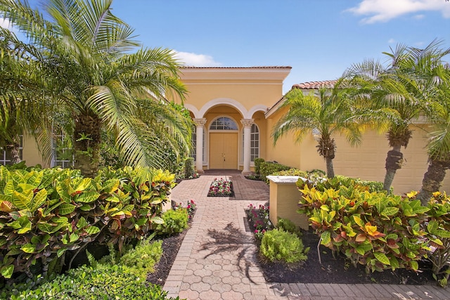 8873 Via Brilliante, Wellington, FL 33411 - property entrance with stucco siding, an attached garage, and a tile roof