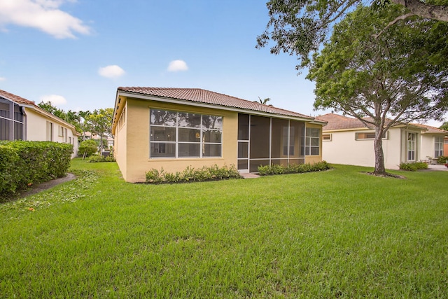 8873 Via Brilliante, Wellington, FL 33411 - rear view of house with stucco siding, a tile roof, a lawn, and a sunroom