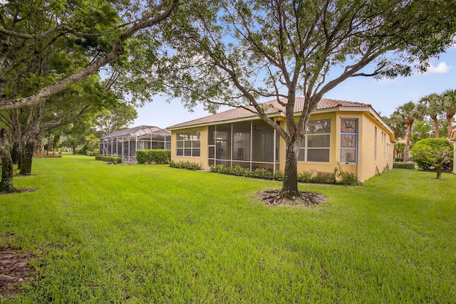 8873 Via Brilliante, Wellington, FL 33411 - rear view of house featuring a sunroom, a tile roof, a yard, and stucco siding