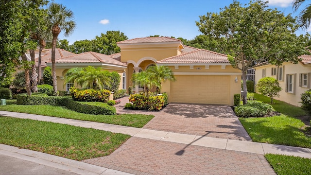 8873 Via Brilliante, Wellington, FL 33411 - mediterranean / spanish home with stucco siding, an attached garage, a tile roof, decorative driveway, and a front lawn
