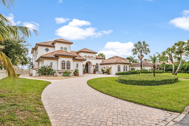 671 Indian River Dr, Melbourne, FL 32935 - mediterranean / spanish home featuring curved driveway, stucco siding, and a tile roof
