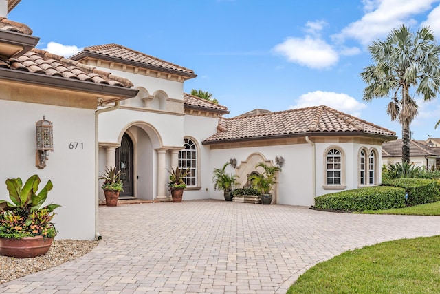 671 Indian River Dr, Melbourne, FL 32935 - view of front facade with curved driveway, stucco siding, and a tile roof