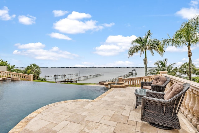 671 Indian River Dr, Melbourne, FL 32935 - view of swimming pool featuring a pool with connected hot tub, a water view, and a patio area