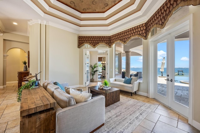 671 Indian River Dr, Melbourne, FL 32935 - living area with ornamental molding, arched walkways, a tray ceiling, a water view, and french doors