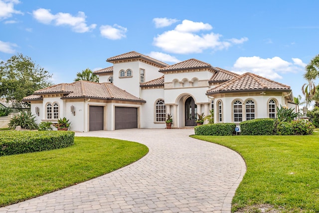 671 Indian River Dr, Melbourne, FL 32935 - mediterranean / spanish house with a garage, stucco siding, french doors, a front lawn, and curved driveway
