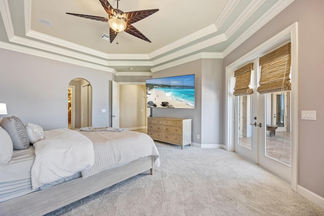 671 Indian River Dr, Melbourne, FL 32935 - bedroom featuring a tray ceiling, arched walkways, french doors, crown molding, and access to exterior