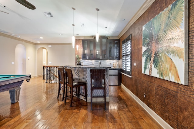 671 Indian River Dr, Melbourne, FL 32935 - indoor wet bar featuring arched walkways, crown molding, wood-type flooring, freestanding refrigerator, and billiards