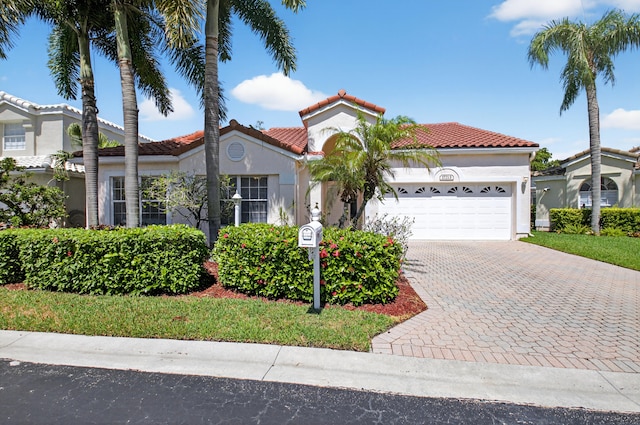 17213 Balboa Point Way, Boca Raton, FL 33487 - mediterranean / spanish-style house featuring an attached garage, stucco siding, decorative driveway, and a tiled roof